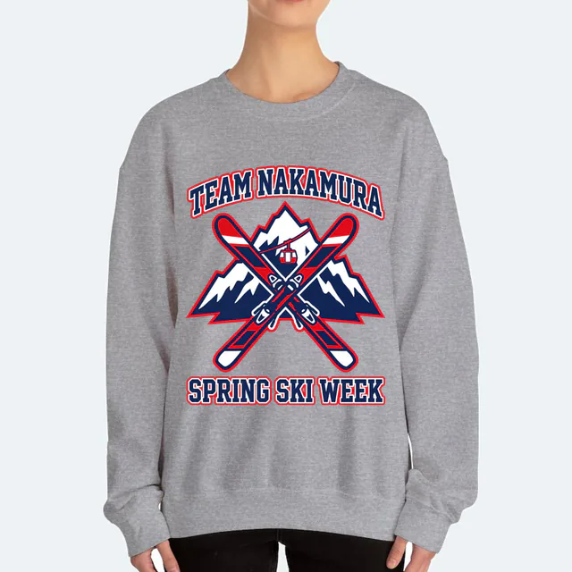 Crossed skis before a snowy peak for Team Nakamura ski week, on a sport gray adult crewneck