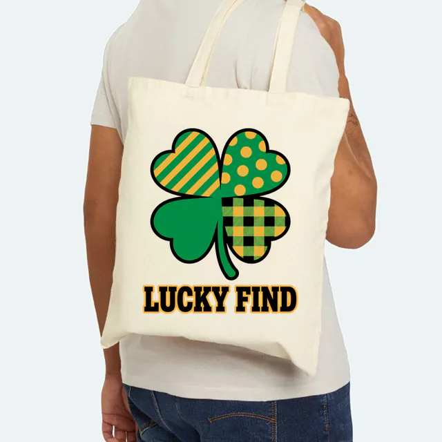 A patchwork four-leaf clover over LUCKY FIND, on a natural canvas tote