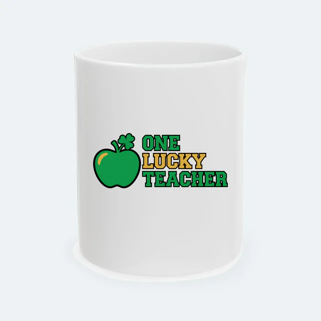 A green apple sprouting a shamrock, ONE LUCKY TEACHER, on a white ceramic mug