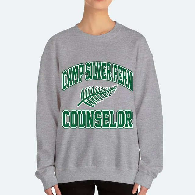 CAMP SILVER FERN arched over a fern frond, COUNSELOR, on a sport gray adult crewneck