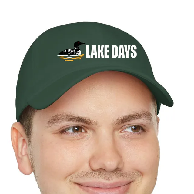 A loon on the water beside LAKE DAYS, on a dark green dad hat