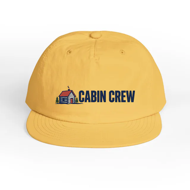 A tiny log cabin beside CABIN CREW, on a sunset surf cap