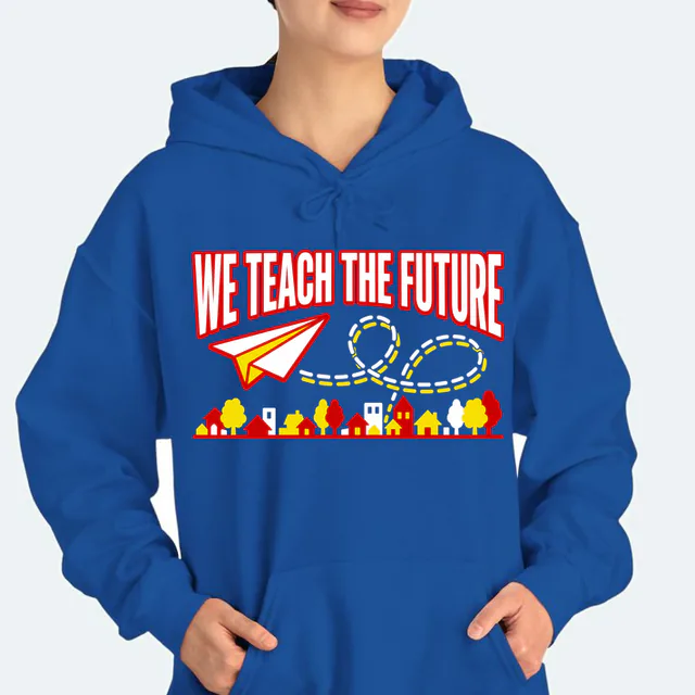 A paper airplane looping over rooftops, WE TEACH THE FUTURE, on a royal adult hoodie