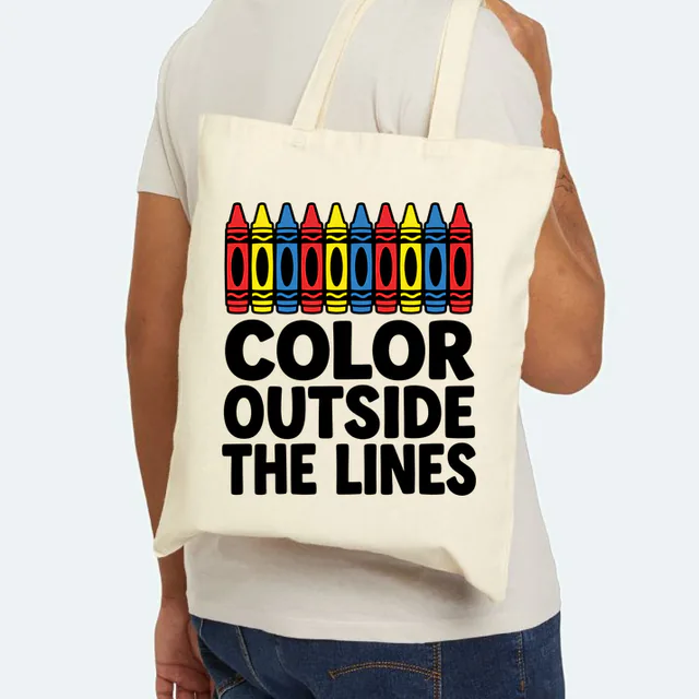 A row of chunky crayons, COLOR OUTSIDE THE LINES, on a natural canvas tote