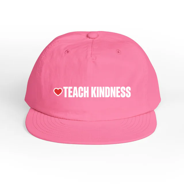 A small heart beside TEACH KINDNESS, on a charity pink surf cap
