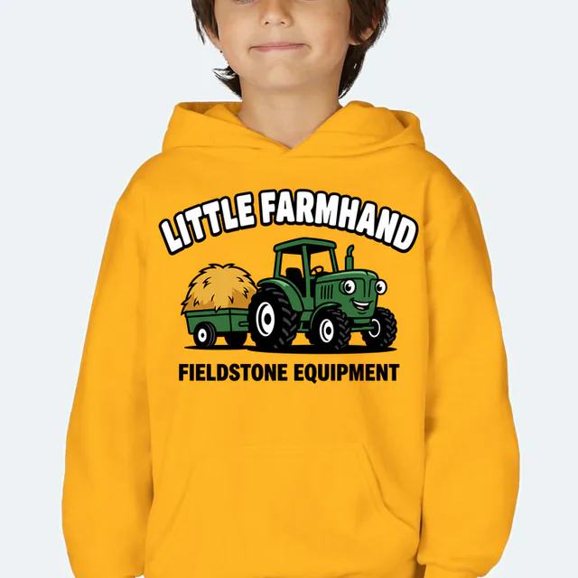 A smiling tractor pulling hay, LITTLE FARMHAND, on a gold youth hoodie