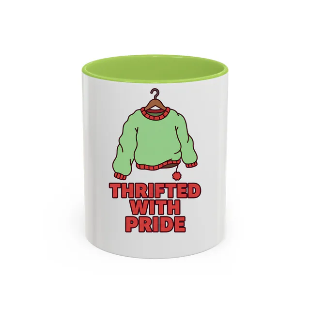 A lopsided sweater on a hanger, THRIFTED WITH PRIDE, on a light green accent mug