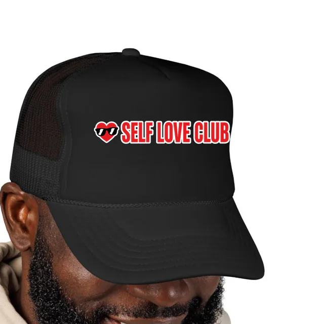 A heart in sunglasses beside SELF LOVE CLUB, on a black foam trucker hat
