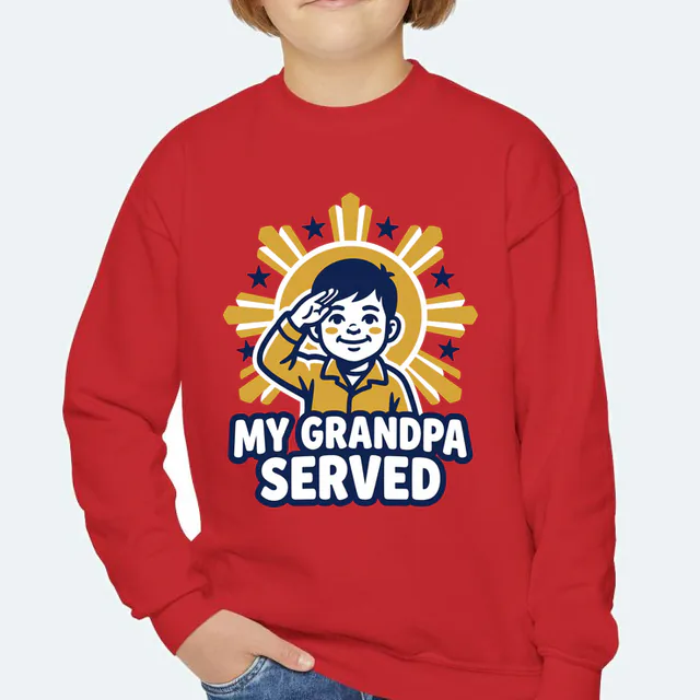 A kid saluting before a rising sun, MY GRANDPA SERVED, on a red youth crewneck