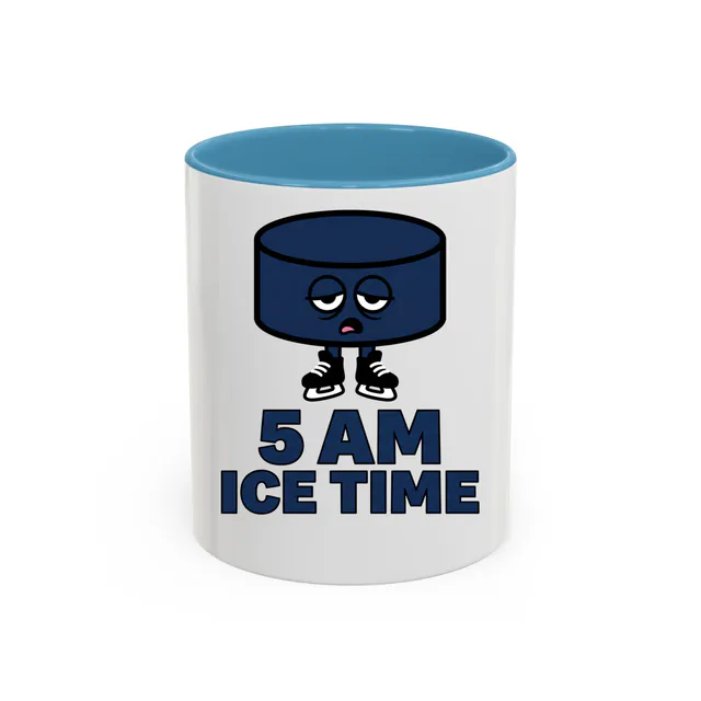 A sleepy hockey puck in skates, 5 AM ICE TIME, on a light blue accent mug
